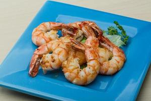 Tiger shrimps on the plate and wooden background photo