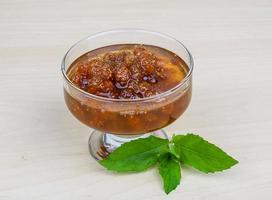 Mulberry jam in a bowl on wooden background photo