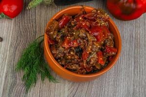 Eggplant caviar in a bowl on wooden background photo