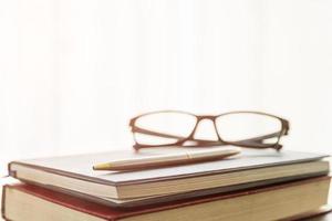 Glasses and book on the desk photo