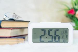 Digital clock with book decorated on table photo