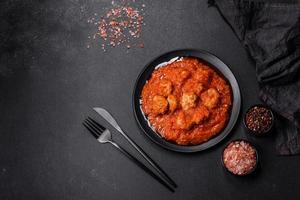 Delicious meatballs made from ground beef in a spicy tomato sauce photo