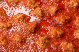 Delicious meatballs made from ground beef in a spicy tomato sauce photo