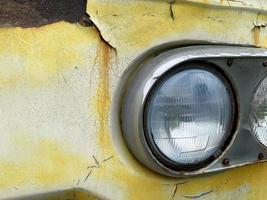 Yellow classic car headlights, Corrosive paint on the front of the car photo