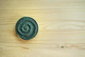 Chlorella or spirulina powder on a light wooden background with copy space photo