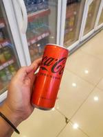 Jakarta, Indonesia in July 2022. A hand is holding a can of fizzy drink, coca - cola zero sugar. photo