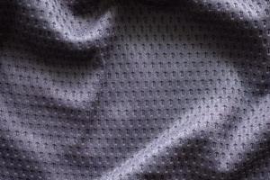 camiseta de fútbol de ropa deportiva de tela gris con fondo de textura de malla de aire foto