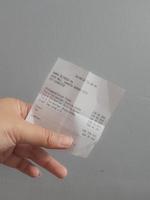 Jakarta, Indonesia in July 2022. A hand is holding a shopping receipt. photo