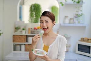 Asian woman eating tasty traditional spring rolls photo