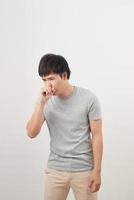 handsome man coughing into his fist, isolated on a white background photo