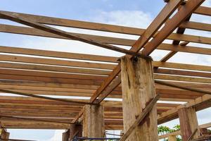 una estructura de marco de madera con pilares de soporte masivos prepara la construcción de una casa de dos pisos. foto