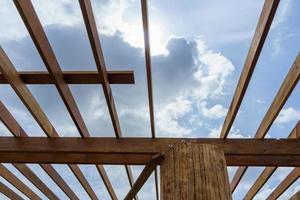 The wooden house structure is under construction reflecting the sunlight. photo