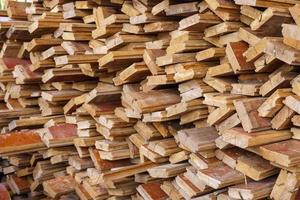 irregularly stacked timber abstract background, Old wooden boards preparing for the construction of the house, Pattern on the edge of several pieces of wood photo