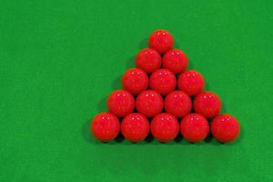 vista superior de 15 bolas de billar rojas en una mesa de billar de terciopelo verde. foto
