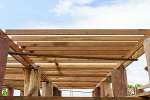 A wooden frame structure with massive supporting pillars prepares the construction of a two-story house. photo