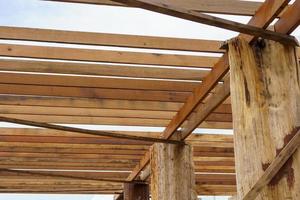 A wooden frame structure with massive supporting pillars prepares the construction of a two-story house. photo