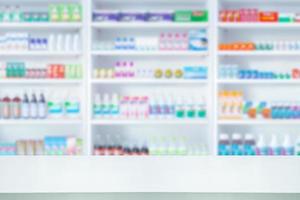 Empty white counter with pharmacy drugstore shelves blurred background photo