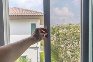 Hand hold mosquito net wire screen handle on house window photo