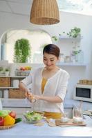 Woman putting salt in bowl. photo