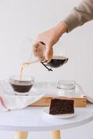 Brewing nel drip coffee. Step by step cooking instructions. Coffee is ready. Barista pouring brewed coffee in the cup photo