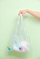 Female hand holding a waste bag isolated on white background. photo