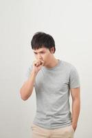 handsome man coughing into his fist, isolated on a white background photo
