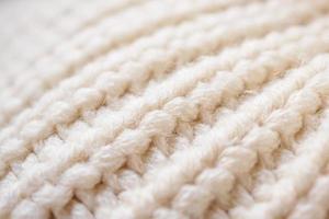 closeup beige knitted woolen fabric texture background photo