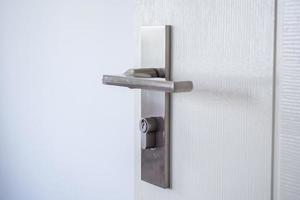 Modern door handle with on white door photo