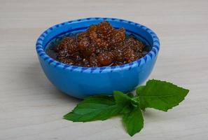 Mulberry jam in a bowl on wooden background photo