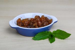 Mulberry jam in a bowl on wooden background photo