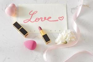 Pink Valentines day flat lay with a lipstick kiss and flowers. Top view photo