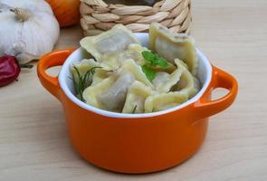 Ravioli in a bowl on wooden background photo