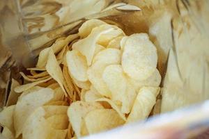 Potato chips in open snack bag close up photo