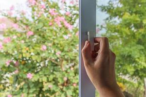 Hand hold mosquito net wire screen handle on house window photo