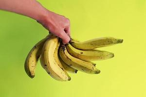 Big bunch of yellow bananas on green background photo