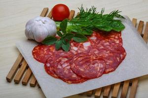 Chorizo sausage on wooden board and wooden background photo