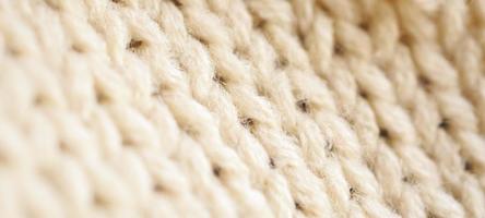 closeup beige knitted woolen fabric texture background photo