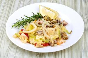 Seafood cocktail on the plate and wooden background photo