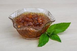 Mulberry jam in a bowl on wooden background photo