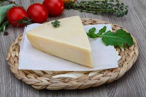 Parmesan cheese on wooden board and wooden background photo