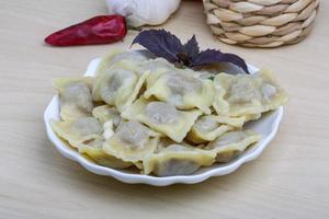 raviolis en el plato y fondo de madera foto