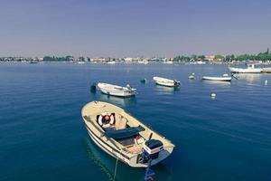 A photograph of a ship and a luxury yacht anchored in port. Beautiful photo of a Mediterranean port