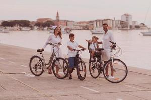 The happy family enjoys a beautiful morning by the sea riding a bike together and spending time together. The concept of a happy family photo