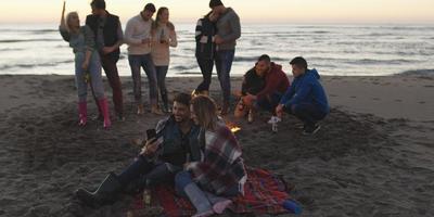 Friends having fun at beach on autumn day photo