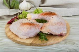 Chicken thigh on wooden board and wooden background