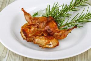 Grilled quail on the plate and wooden background photo