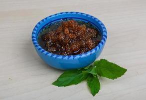 Mulberry jam in a bowl on wooden background photo