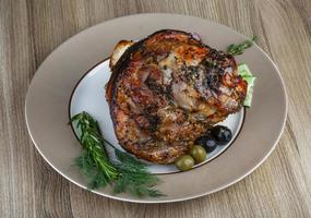 Pork knee on the plate and wooden background photo