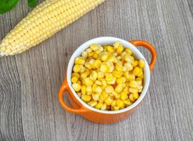 Sweet corn in a bowl on wooden background photo