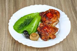 Teriyaki chicken on the plate and wooden background photo